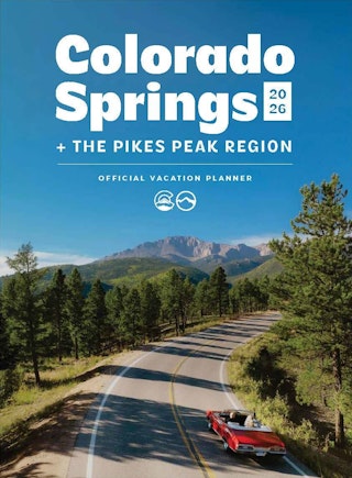 Cover for 2026 Colorado Springs Vacation planner that shows a red convertible driving up a mountain pass towards Pikes Peak under blue skies